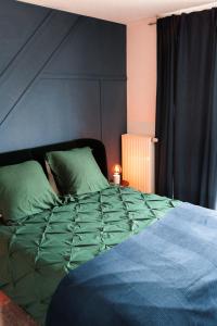 uma cama com um edredão verde num quarto em Industrial Apartment in Belval the University City em Esch-sur-Alzette