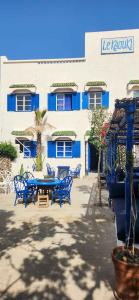a table and chairs in front of a building at Hotel-Restaurant Le Kaouki in Sidi Kaouki