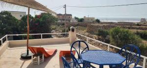 a patio with two chairs and a table on a balcony at Hotel-Restaurant Le Kaouki in Sidi Kaouki