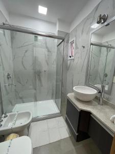 La salle de bains est pourvue d'une douche, d'un lavabo et de toilettes. dans l'établissement Regia Apartamentos Villa Sarita, à Posadas