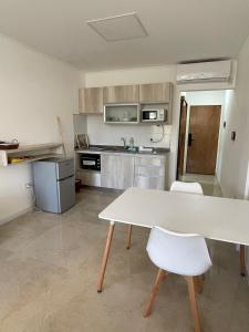 une cuisine avec une table blanche et deux chaises blanches dans l'établissement Regia Apartamentos Villa Sarita, à Posadas