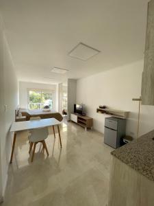 a living room with a table and a kitchen at Regia Apartamentos Villa Sarita in Posadas +6 photos