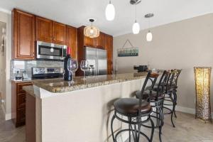 a kitchen with a counter with stools at a bar at Beachy Daze-Waterfront - WIFI - Heated Pool in Tampa
