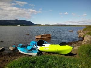 two kayaks are parked on the shore of a lake at Austurey - Lakefront Villa in Laugarvatn