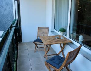 d'une table en bois et de deux chaises sur un balcon. dans l'établissement The Lodge Braunlage, à Braunlage