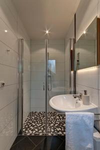 ein weißes Bad mit einem Waschbecken und einer Dusche in der Unterkunft Ferienwohnung Yvonne in Oberhausen