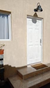 Una puerta blanca en una habitación con ventana en Los Cerezos de Ema en Puerto Iguazú