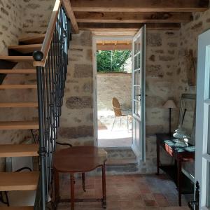 a staircase in a room with a door and a table at Manoir de la Chapelle in Condé-sur-Sarthe