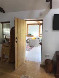 Zimmer mit einer Tür zum Wohnzimmer in der Unterkunft Garden View in Saxlingham Thorpe