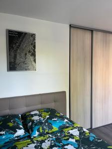 1 dormitorio con 1 cama y una foto en la pared en Superbe appartement au bord du canal de St Quentin, en Saint-Quentin