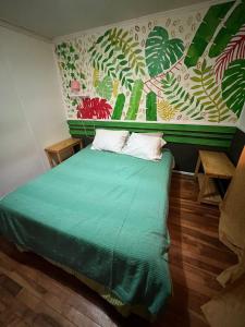 1 dormitorio con 1 cama verde y 2 almohadas en Isla Yu Patagonia 2, en Puerto Natales