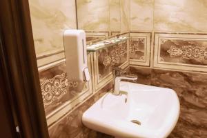 y baño con lavabo blanco y espejo. en Styopa Hotel en Ereván