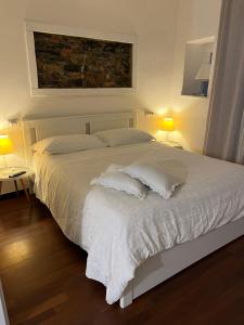 a bedroom with a bed with white sheets and pillows at Golfo Dei Poeti Apartment in Lerici