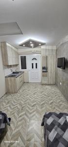 Großes Zimmer mit einer Küche und einer weißen Tür. in der Unterkunft Ekonomic Apartmani in Golubovci