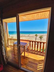 uma varanda com uma mesa e vista para a praia em Kélibia beach chalets em Kelibia