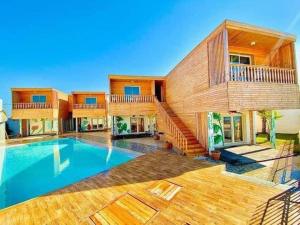 a home with a swimming pool and a house at Kélibia beach chalets in Kelibia