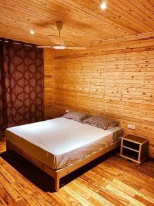 a bedroom with a bed and a wooden wall at Kélibia beach chalets in Kelibia