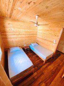 um quarto com 2 camas num chalé de madeira em Kélibia beach chalets em Kelibia