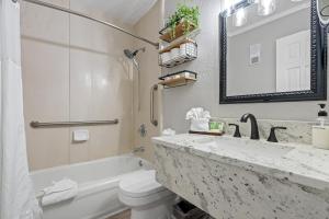 a bathroom with a sink and a toilet and a mirror at Wake up to the ocean breeze - Enjoy amazing views in Tampa