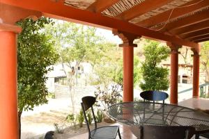 a patio with a table and chairs on a porch at La casita in Álamos