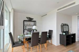 a dining room with a glass table and black chairs at Queen Chelsea 77 in London