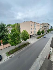 an empty street in a city with trees and buildings at Łódź4HOME Apartament in Łódź