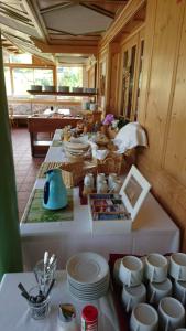 einem langen Tisch mit weißen Tellern und Tassen darauf in der Unterkunft Gasthof Schönblick Rußbach in Gseng