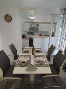 einen Esstisch und Stühle in der Küche in der Unterkunft Apartman Oaza - Ploče, Croatia in Ploče