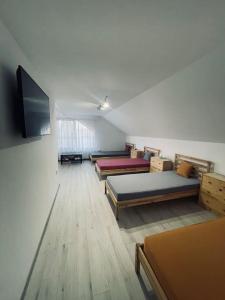 a room with four beds and a flat screen tv at ViiLa TO in Bertea
