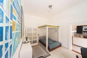 ブダペストにあるCosy studio apartment with AirConditionerのベッド1台とソファが備わる小さな客室です。
