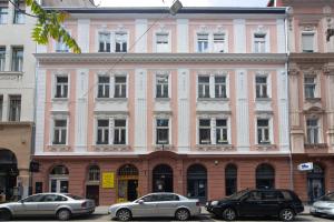 ブダペストにあるCosy studio apartment with AirConditionerの車が目の前に停まったピンクの建物