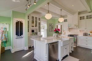 a large kitchen with green walls and white cabinets at Captain's Quarters East Nashville, Tn (Five Point) in Nashville