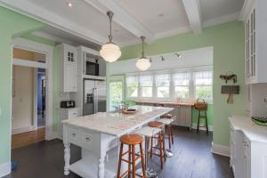 een keuken met groene muren en een wit kookeiland met barkrukken bij Captain's Quarters East Nashville, Tn (Five Point) in Nashville