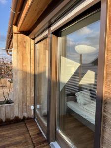 a glass window of a balcony with a bed at Spacious apartment with shared jacuzzi/private terrace in Budapest