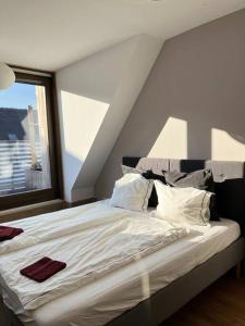 Bett in einem Zimmer mit einem großen Fenster in der Unterkunft Spacious apartment with shared jacuzzi/private terrace in Budapest