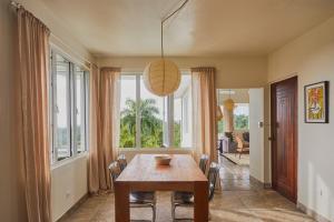 a dining room with a table and some windows at WALD HAUS by DW in Naguabo