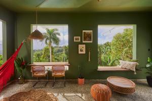 a room with a green wall with a hammock in it at WALD HAUS by DW in Naguabo