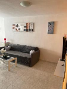 - un salon avec un canapé et une table dans l'établissement Apartament Monserrat, à Torrevieja