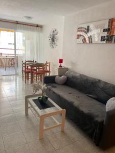 - un salon avec un canapé et une table dans l'établissement Apartament Monserrat, à Torrevieja