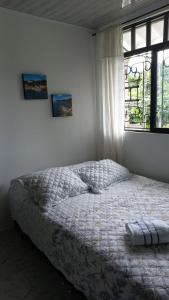 1 cama en un dormitorio con ventana en Apartamentos El Caudal, Villavicencio en Villavicencio