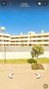 a large building with a tree in front of it at BEACH FRONT APARTMENT - with swimming pool, barbecue and tennis court! in Viana do Castelo