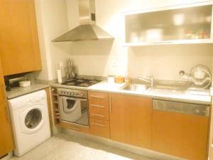 a kitchen with a sink and a washing machine at BEACH FRONT APARTMENT - with swimming pool, barbecue and tennis court! in Viana do Castelo