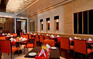 a dining room with tables and chairs in a restaurant at Fortune Park JPS Grand Rajkot - Member ITC Hotels' Group in Rajkot