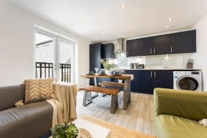 a kitchen and living room with blue cabinets at Spacious, newly renovated, three bedroom TOWN CENTRE duplex apartment with free parking, sleeps seven - Walking distance to beach in Bournemouth