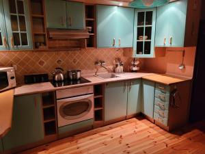 a kitchen with blue cabinets and a sink and a stove at Przestronny apartament in Przasnysz