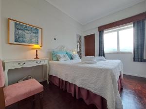 1 dormitorio con 1 cama con mesa y ventana en SolMar View Apartment, Azores en Ponta Delgada