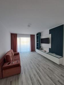 een woonkamer met een bank en een flatscreen-tv bij Happy Rental Apartments 2 in Craiova