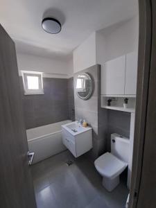 a bathroom with a sink and a toilet and a bath tub at Happy Rental Apartments 2 in Craiova