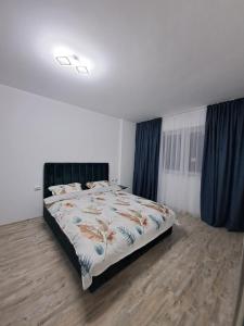 een slaapkamer met een groot bed en blauwe gordijnen bij Happy Rental Apartments 2 in Craiova