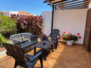 a patio with two chairs and a table and chairs at Juangy’s Apartments in Las Adelfas Golf del Sur in San Miguel de Abona